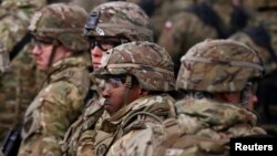 FILE - U.S. soldiers attend a welcoming ceremony for U.S.-led NATO troops at a military training site near Orzysz, Poland, April 13, 2017. 