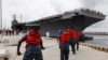 FILE - Navy crews haul in lines as the USS Abraham Lincoln arrives at Naval Station Norfolk in Norfolk, Virgina, Aug. 7, 2012. The U.S. has dispatched the aircraft carrier to the Middle East following “clear indications” that Iran was preparing to possibly attack U.S. forces.