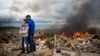 Michael Stanek hugs his daughter Kennedy Stanek as they take a break from helping friends sift though the rubble of their homes in Vilonia, Arkansas, April 30, 2014.
