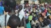 FILE - Women wait for grain to feed their families, at Doro refugee camp in South Sudan.