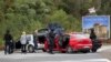 Polisi Kosovo menggeledah kendaraan di persimpangan jalan menuju Biara Banjska selama operasi yang sedang berlangsung di desa Banjska, Kosovo, 25 September 2023.