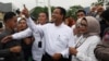 Anies Baswedan menunjukkan jari yang sudah dicelup tinta usai memberi suara dalam pemilihan presiden, di Jakarta, 14 Februari 2024. (Foto: Ajeng Dinar Ulfiana/Reuters)