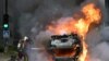 A firefighter extinguishes a burning car at the end of a commemoration march for a teenage driver shot dead by a policeman, in the Parisian suburb of Nanterre, France, June 29, 2023.