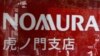 FILE - People are reflected on a window outside a Nomura Securities branch in Tokyo in this 2013 file photo. Charles Wang Zhonghe, China investment banking chairman at Nomura, is prohibited from traveling outside mainland China, sources report.