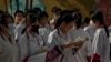 北京的中学生在进入高考考场前温习功课。（2023年6月7日）