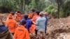 This handout photo released on April 14, 2024 by the National Search and Rescue Agency (BASARNAS) shows rescuers carrying a body bag at a landslide site in Tana Toraja, South Sulawesi. 