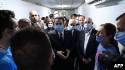 A handout photo released by the press office of Iraq's prime minister on its Facebook page Sept. 28 2023, shows Prime Minister Mohammed Shia al-Sudani (C) meeting at a hospital in Mosul with families of victims of a wedding hall fire.