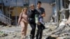 Employees leave a restaurant building hit by recent shelling that local Russian-installed authorities called a Ukrainian military strike in Donetsk, Russian-controlled Ukraine, May 11, 2024.