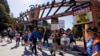 FILE — SAG-AFTRA actors and Writers Guild of America writers picket outside Disney Studios in Burbank, California, July 25, 2023. The guild said its members could return to work on Wednesday while a ratification vote takes place on a new contract with Hollywood studios. 
