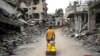A Palestinian man pulls a boy on a cart on a street lined with destroyed buildings in Khan Yunis in the southern Gaza Strip, May 2, 2024, amid the ongoing conflict between Israel and the militant Hamas movement.