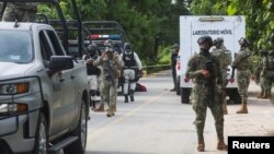 Mexican armed forces stand guard near a crime scene where several local police officers were shot dead by gunmen, in Coyuca de Benitez, Mexico, Oct. 23, 2023.