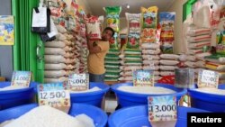 Seorang pedagang menata sekarung beras di pasar tradisional Bekasi, 1 Maret 2024. (Foto: REUTERS/Ajeng Dinar Ulfiana)