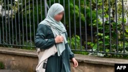 FILE- Photo taken August 28, 2023 of a woman wearing an abaya walking in Paris. The education minister said August 27, 2023, the garment violates France's strict secular laws in education.