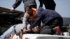 An injured Palestinian is lifted onto an ambulance during clashes with Israeli forces in the West Bank city of Nablus, Wednesday, Feb. 22, 2023. 