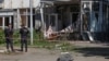 Police officers stand next to a building hit by what local authorities called a Ukrainian military strike, in Belgorod, Russia, May 9, 2024.
