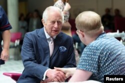 Britain's King Charles meets with patient Jasper Keech during a visit to the University College Hospital Macmillan Cancer Centre in London, Britain, April 30, 2024.