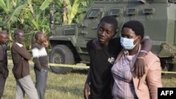 Um rapaz é confortado na Escola Secundária Mpondwe Lhubiriha. oeste do Uganda após ataque de militantes ligados ao grupo do Estado Islâmico 
