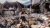 Mustafa Ozdimir helps his family as they collect goods from their collapsed shop in the city of Antakya on Feb. 19, 2023. 