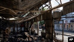 FILE - People clear the rubble of a market destroyed in a rocket attack the day before in Kostiantynivka, Ukraine, Sept. 7, 2023. 