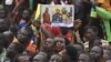 FILE - A man holds a placard with the image of Niger's new military ruler General Abdourahamane Tiani on as people protest outside the Niger and French airbase in Niamey on Sept. 2, 2023 to demand the departure of the French army from Niger.