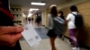 Salah satu petugas sekolah di SMA Olathe South di Olathe, Kansas, menunjukkan tombol peringatan bahaya yang diberlakukan dii sekolah tersebut pada 19 Agustus 2022. (Foto: AP/Charlie Riedel)