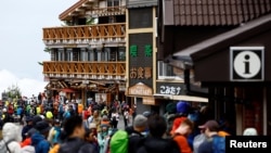 Climbers and visitors gather on the first day of the climbing season at Fuji Yoshidaguchi Trail (Yoshida Route) at the fifth station on the slopes of Mount Fuji, in Fujiyoshida, Yamanashi Prefecture, Japan, July 1, 2024. 