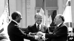 Egyptian President Anwar Sadat, U.S. President Jimmy Carter and Israeli Prime Minister Menachem Begin clasp hands on the north lawn of the White House after signing the peace treaty between Egypt and Israel in Washington, March 26, 1979.