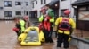 Rescue workers evacuate a family trapped at home in a flooded street in Brechin, northeast Scotland, on Oct. 20, 2023, as Storm Babet batters the country.