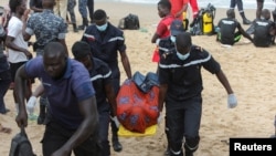 Anggota tim evakuasi membawa jenazah migran di pantai Oukam pada 24 Juli 2023. Kapal yang membawa migran tersebut tenggelam di lepas pantai Dakar, Senegal, saat mencoba menyeberang. (Foto: Reuters/Ngouda Dione)