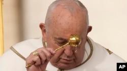 Pope Francis asperses holy water as he celebrates Easter Mass in St. Peter's Square at the Vatican, March 31, 2024. 