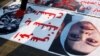 FILE - An Iraqi demonstrator steps on pictures of former Iraqi President Saddam Hussein and his daughter Raghad Saddam Hussein during anti-government protests in Baghdad, Iraq, Dec. 23, 2019.