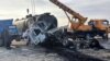 This handout photo released by Afghanistan's Helmand Information Department shows the wreckage of a passenger bus and oil tanker after the bus collided with a motorbike, then crashed into the tanker in Helmand province, killing 21 people, on March 17, 2024.