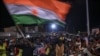 FILE - Supporters of Niger's National Concil for the Safeguard of the Homeland display a National flag as they protest ouside a French and Niger airbase in Niamey on Sept. 9, 2023 to demand the departure of the French army from Niger. 