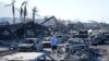 A man walks through wildfire wreckage Aug. 11, 2023, in Lahaina, Hawaii. 