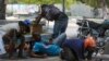 People take cover from gunfire during clashes between police and gangs in the Champs de Mars area next to the National Palace in Port-au-Prince, Haiti, April 8, 2024.