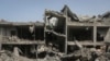 Palestinians look at the destruction after an Israeli strike on a residential building in Nuseirat Refugee Camp, Gaza Strip, May 19, 2024.