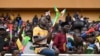 A man waves Niger, Mali and Burkina Faso flags as supporters cheer from the stands while artists perform during a concert in support to Niger's National Council for the Safeguard of the Homeland at General Seyni Kountche Stadium in Niamey, Aug. 13, 2023. 