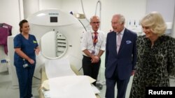 Britain's King Charles and Queen Camilla look at the CT scanner during a visit to the University College Hospital Macmillan Cancer Centre in London, Britain, April 30, 2024.