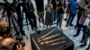 Journalists gather around a showcase displaying a Roman-era javelin and four swords found in a Judean Desert cave, presented at the Jay and Jeanie Schottenstein National Campus for the Archeology of Israel, in Jerusalem, Sept. 6, 2023. 