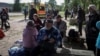Residents of Vovchansk and nearby villages wait for buses amid an evacuation to Kharkiv due to Russian shelling, near the town of Vovchansk, in Ukraine's Kharkiv region, May 10, 2024.