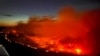 FILE - The Parker Lake wildfire glows in a photograph taken by a B.C. Emergency Health Services crew member through the window of an airplane evacuating patients from nearby Fort Nelson, British Columbia, Canada, May 10, 2024. 