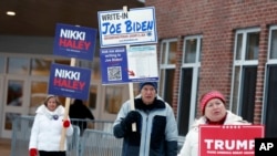 ARCHIVO - Simpatizantes de candidatos frente a un centro de votación en las elecciones primarias del 23 de enero de 2024, en Windham, New Hampshire. El supermartes a la vista con los principales contendientes presidenciales ya pareciendo estar listos.