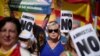 A protester holds 'No to amnesty' sign during a right-wing protest against plans to grant Catalan separatists an amnesty in order to form Spain's next government, in Barcelona on Oct. 8, 2023. 