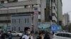 FILE - People walk past a police station in Urumqi, the capital of China's far west Xinjiang region, on April 21, 2021. Prominent Uyghur scholar Rahile Dawut, not pictured, reportedly has been sentenced to life in prison for "endangering state security." 