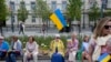 Люди з українськими прапорами у Вільнюсі в Литві, де станом на серпень 2023 р. зареєстровані понад 72 000 біженців від російської війни в Україні. Фото 11 липня 2023 р.