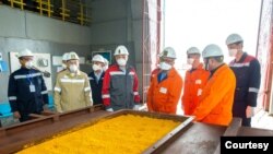 资料照片：哈萨克斯坦国家原子能工业公司的照片显示该公司的工作人员在该国南部的采矿设施中查看铀黄饼。（2022年4月22日）