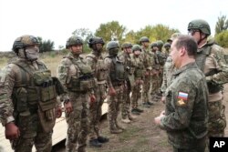 Wakil Ketua Dewan Keamanan Rusia Dmitry Medvedev, kanan depan, berbicara kepada anggota militer Rusia selama kunjungannya di tempat pelatihan militer di wilayah Donetsk yang dikuasai Rusia, Ukraina, 15 September 2023. (Foto: via AP)