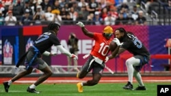 FILE - Tyreek Hill (10) dari Miami Dolphins membawa bola melawan cornerback NFC Tariq Woolen (27) dari Seattle Seahawks dan gelandang luar Za'Darius Smith (55) dari Minnesota Vikings pada pertandingan sepak bola NFL Pro Bowl, di Las Vegas, 5 Februari 2023. (AP/David Becker, File)