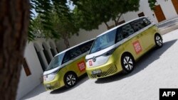 Volkswagen ID. Buzz vehicles are parked outside the venue hosting the Geneve International Motor Show (GIMS) in Doha on Oct. 1, 2023, after crossing through 12 countries to arrive in Qatar from Geneva. 