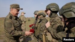 Menteri Pertahanan Rusia Sergei Shoigu memberikan penghargaan kepada anggota militer saat ia mengunjungi tempat pelatihan distrik militer selatan Rusia, 5 Oktober 2023. (Foto: via Reuters)